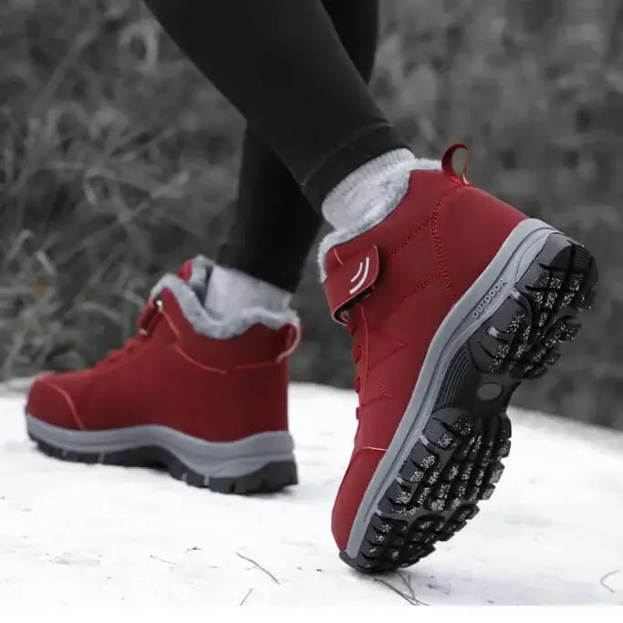 Eine Frau mit Rot Ergonomischen Winter-Barfußschuhen von Vanea Barfußschuhe im Schnee