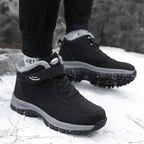 Ein Mann trägt Schwarz Ergonomische Winter-Barfußschuhe von Vanea Barfußschuhe im Schnee